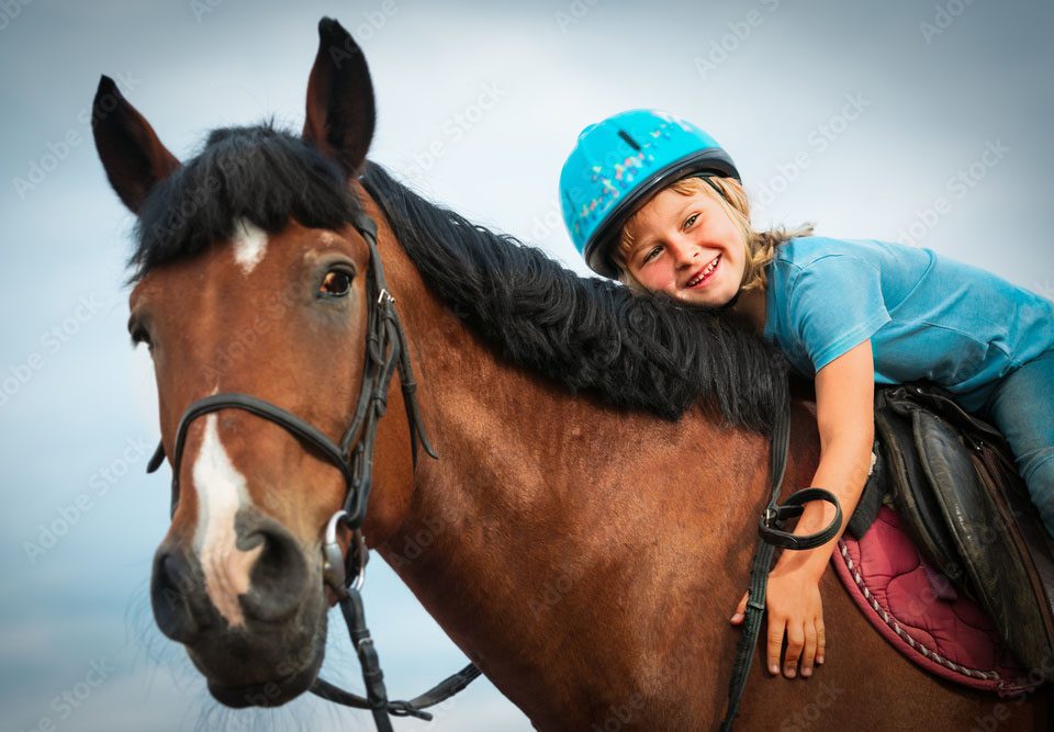 Child hugging horse while riding
